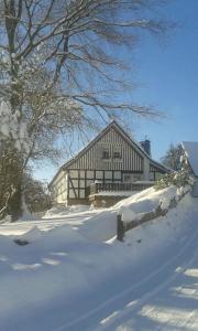 een groot huis in de sneeuw met een tuin bij Ferienwohnung Krähling in Schmallenberg