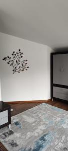 a room with a white wall with a tree sticker on the wall at Verde viu in Greşu