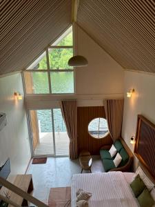 a bedroom with a bed and a couch and a window at ชอว์ งาทอง รีสอร์ต Chor Ngar Thong Erawan Kanchanaburi in Tha Kradan