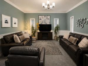 a living room with leather couches and a flat screen tv at NEWCASTLE COUNTRY INN in Drumheller