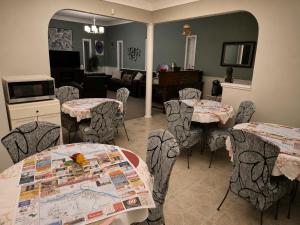 a room with tables and chairs and a living room at NEWCASTLE COUNTRY INN in Drumheller