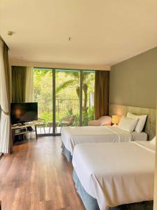 a hotel room with two beds and a flat screen tv at Chốn Mộc - Cát Bà Resort in Cat Ba +39 photos