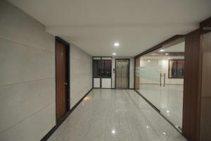 an empty hallway of a building with glass doors at Royal Palace Hotel Surat Velanja in Sāyan +34 photos