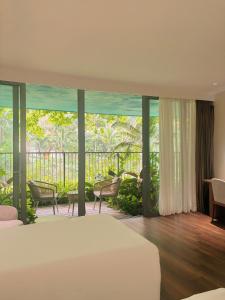 a bedroom with a bed and a balcony at Chốn Mộc - Cát Bà Resort in Cat Ba