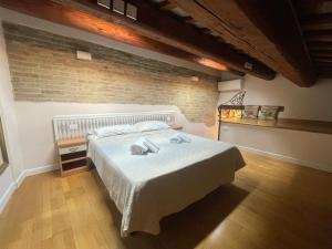 a bedroom with a bed and a brick wall at Residence Cavour 63 in Ravenna
