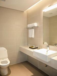 a bathroom with a sink and a toilet and a mirror at Chốn Mộc - Cát Bà Resort in Cat Ba