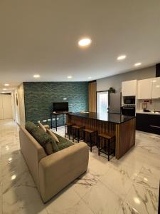 a living room with a couch and a kitchen at Casa de Ferias Tranquilo in Bitarães