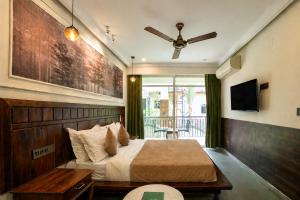 a bedroom with a bed and a ceiling fan at Dimaru Boutique Hotel in Calangute