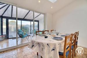 a dining room with a table and some chairs at Les sternes in Étel