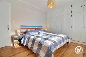 a bedroom with a large bed and a night stand at Les sternes in Étel +25 photos