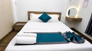 a bedroom with a white bed with blue pillows at Mubee Homestay in Hue