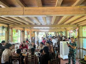 a group of people sitting at tables in a restaurant at Homestay Xuân Sơn 2 in Phú Thọ