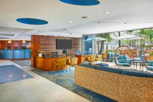 a hotel lobby with a couch and a bar at Courtyard by Marriott Waikiki Beach in Honolulu