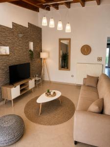 a living room with a couch and a table at Théa Loft Premium Sunset Sea View Escape in Vathý
