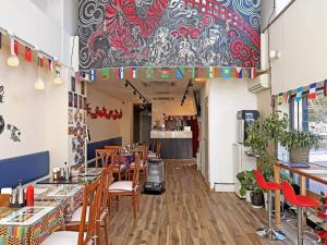 a restaurant with wooden tables and chairs and a colorful wall at Nikko Park Lodge Tobu Station in Nikko