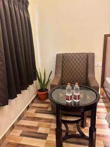 two bottles of water on a table next to a chair at Hotel Gokulam Grand in Tenāli