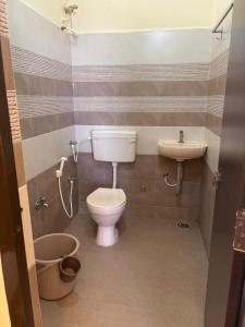 a bathroom with a toilet and a sink at Hotel Gokulam Grand in Tenāli +23 photos