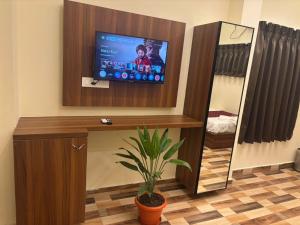 a living room with a tv and a potted plant at Hotel Gokulam Grand in Tenāli