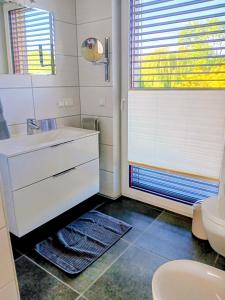a white bathroom with a sink and a toilet at Lagrette Ferienwohnung am Hainer See in Neukieritzsch +12 photos