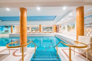 a swimming pool with two columns and two chairs in a hotel at Strandresidenzen Binz in Binz