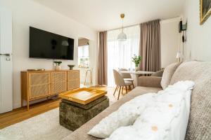 a living room with a couch and a tv at Apartament Flow Tatry in Zakopane