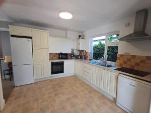 a large kitchen with white appliances and a window at Comfy Home in Castlebar