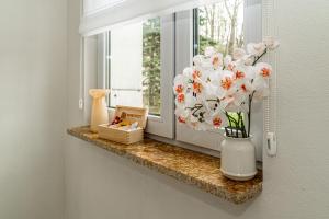 a vase of flowers sitting on a window ledge at Apartament Flow Tatry in Zakopane +25 photos
