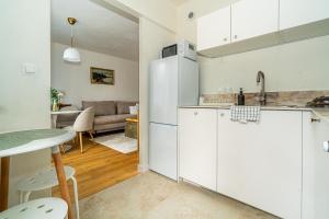 a kitchen and living room with a table and a refrigerator at Apartament Flow Tatry in Zakopane