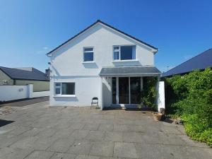 a white house with a chair in a driveway at Comfy Home in Castlebar
