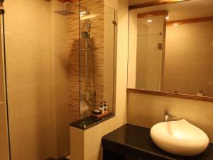 a bathroom with a sink and a glass shower at Resort Thim -Dorji Paro RiverFront in Paro