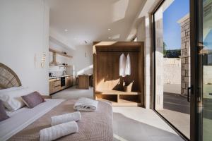 a bedroom with a large bed and a kitchen at Alýria Sea Side Suites in Agios Nikolaos