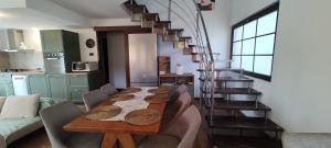 a dining room with a table and a spiral staircase at Verde viu in Greşu