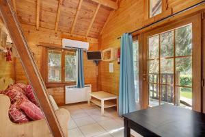 a room with a table and a tv in a cabin at Camping L'imprévu in Vaulnaveys-le-Bas