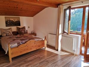 a bedroom with a bed and a large window at Ferienwohnungen Dagn in Kössen
