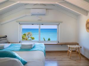 a bedroom with a window with a view of the ocean at GK Beach Hotel in Kalyves
