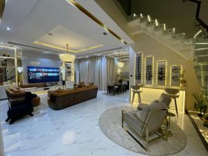 a large living room with a tv and a couch at Luxury 5 BR Villa with Pool,Cinema Lekki in Lekki