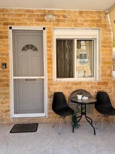 a front door of a house with two chairs and a table at Casa Luna Luxury Apartment in Nea Moudania