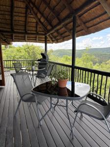 a table and chairs on a deck with a view at Kunkura Game Lodge & Conference Centre in Modimolle