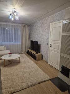 a living room with a tv and a white door at Tamme apartment in Suuremõisa