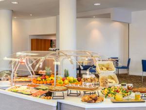 a buffet with many different types of food on a table at Novotel Torino Corso Giulio Cesare in Turin