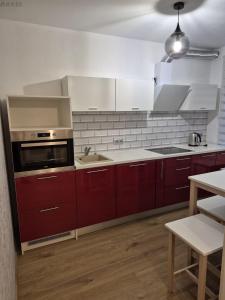 a kitchen with red cabinets and a sink at Tamme apartment in Suuremõisa