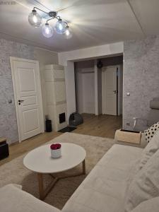 a living room with a white couch and a table at Tamme apartment in Suuremõisa