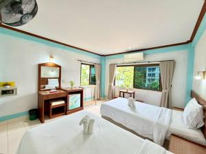 a hotel room with two beds and a mirror at J Mansion in Ao Nang Beach