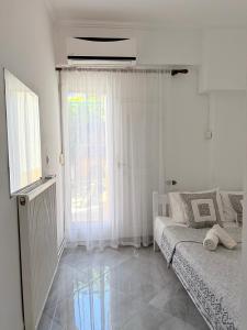 a white room with a bed and a window at Casa Luna Luxury Apartment in Nea Moudania
