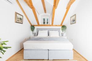 a bed in a room with white walls and wooden ceilings at Ranch Frida in Vodice