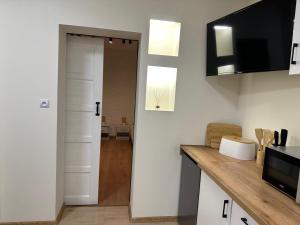 a kitchen with white walls and a counter top at Za Wysokim Murem in Czarne