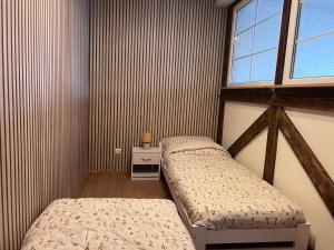 two beds in a small room with a window at Za Wysokim Murem in Czarne