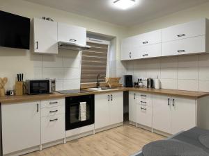a kitchen with white cabinets and a microwave at Za Wysokim Murem in Czarne