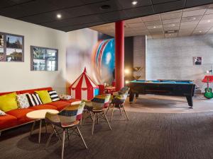 a living room with a couch and a pool table at Ibis Częstochowa in Częstochowa