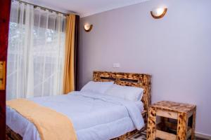 a bedroom with a bed and a window at Pazuri Ark Gardens in Thika